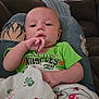 baby, blanket, casual, child, comfort, couch, curtains, face, green_shirt, hand, home, indoor, infant, paw_prints, person, portrait, relaxing, ripped_jeans, sofa, tattoo