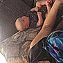 Octavius is registered to the contest to win money with this photo: arm, baby, casual, clothing, couch, expression, face, head, home, indoor, infant, person, pillow, playful, relaxing, seated, shirt, skin, tattoo, tongue