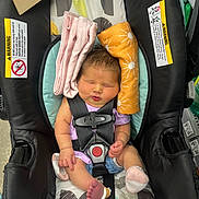 Braelyne joined the competition — help win amazing prizes! baby, newborn, car_seat, infant, safety_harness, sleeping, cloth, pink, orange, toothbrushes, package, footwear, socks, head_support, indoor, retail, product, warning_label, child, person