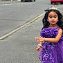 child, girl, purple_dress, tiara, bracelet, street, sidewalk, cars, suburban, portrait, smile, curly_hair, accessories, outdoor, young, person, fashion, happy, cute, walking