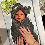 Nova-Rae is registered to the contest to win money with this photo: baby, infant, towel, elephant_costume, hands, rings, bracelet, tree_illustration, face, eyes, blanket, soft_texture, cute, child, newborn, wrapped, person, skin, portrait, cozy