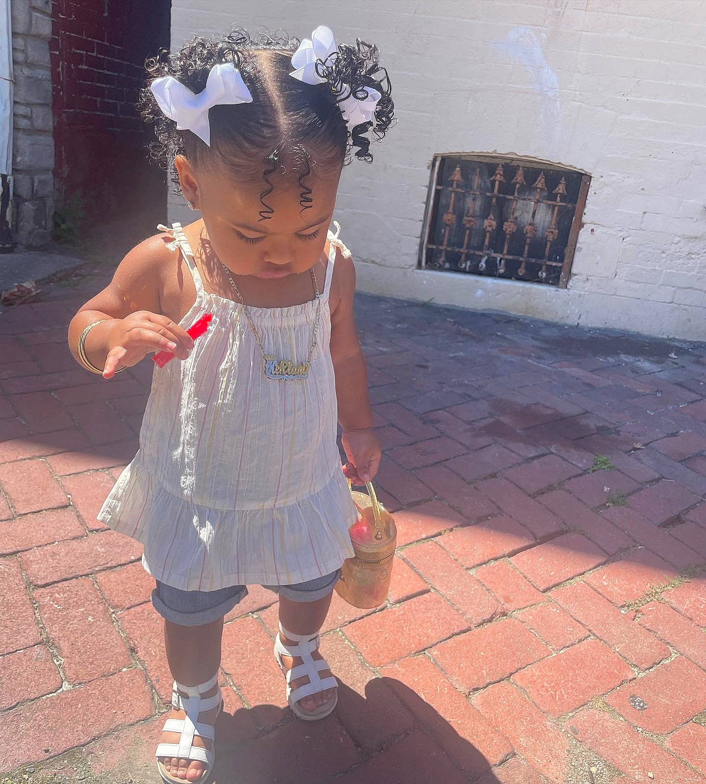 Kehlani is registered to the contest to win money with this photo: baby_toddler_clothing, child, costume, fashion_accessory, flooring, fun, happy, headpiece, human_leg, magenta, metal, morning, pattern, person, pink, play, road_surface, sandal, sidewalk, toddler