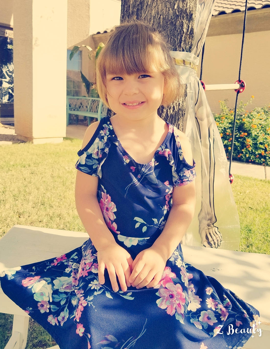 Kira is registered to the contest to win money with this photo: beauty, blue, child, child_model, dress, eye, facial_expression, grass, hair, hairstyle, joy, outerwear, person, photography, pink, sitting, skin, smile, snapshot, summer