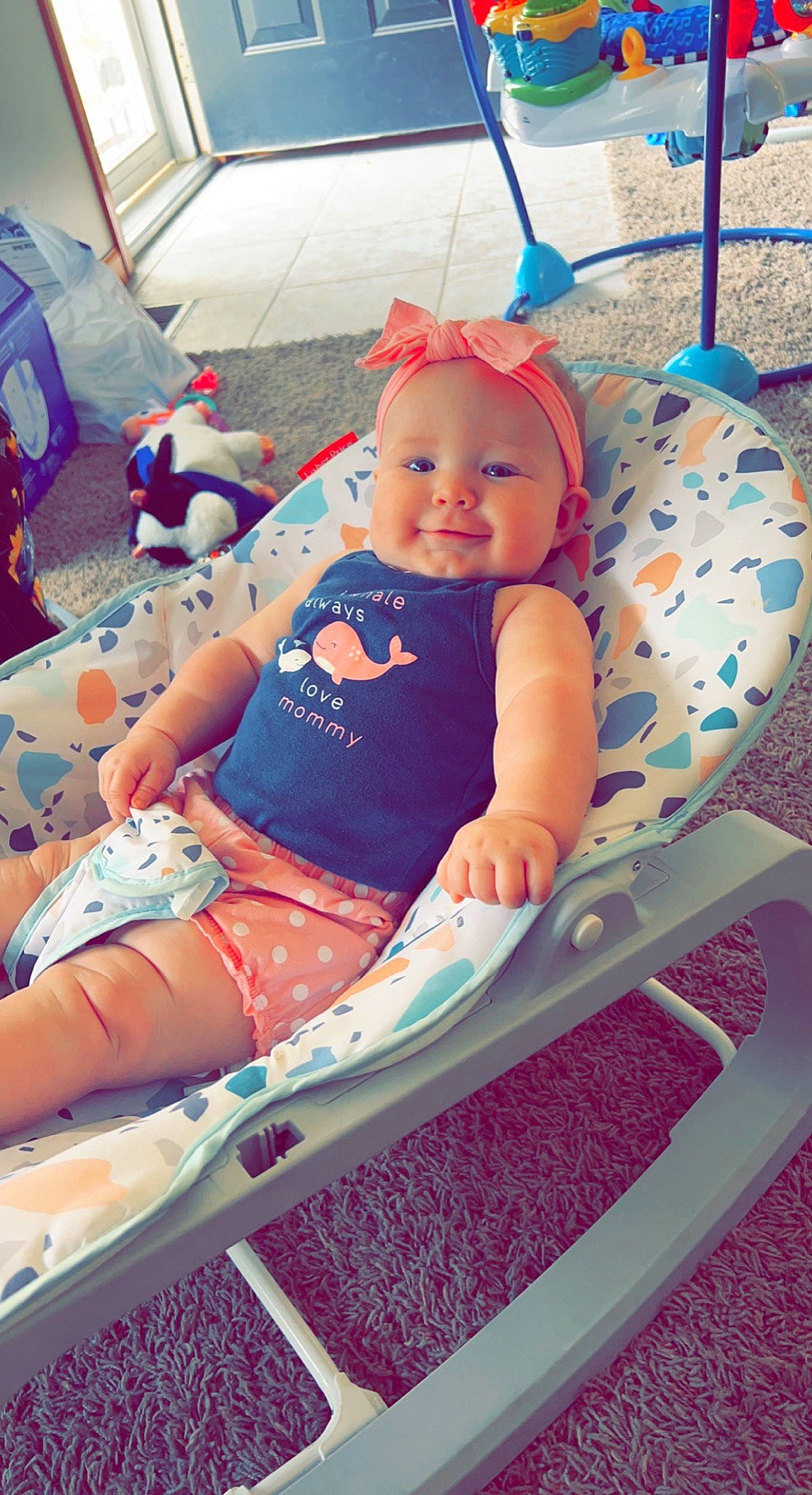 Harper is registered to the contest to win money with this photo: baby, baby_products, baby_toddler_clothing, blue, child, comfort, electric_blue, fun, headwear, human_leg, lap, leisure, person, pink, recreation, shorts, sitting, smile, t_shirt, thigh