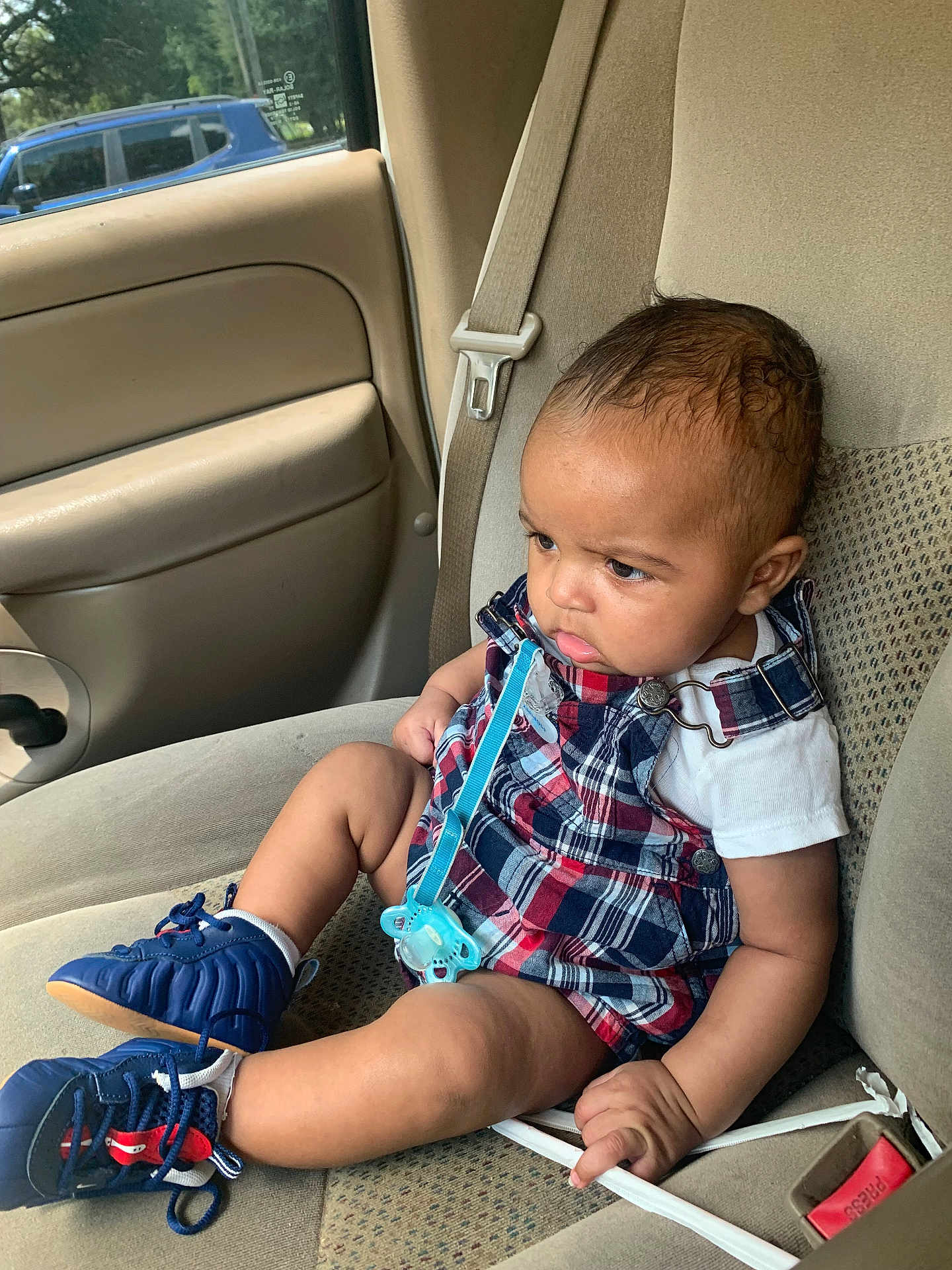 Kaiion joined the competition — help win amazing prizes! baby, child, car_seat, plaid_clothing, blue_sneakers, pacifier, serious_expression, seatbelt, car_interior, window, door, side_view, infant, young_child, sitting, human, casual_wear, footwear, indoors, transportation
