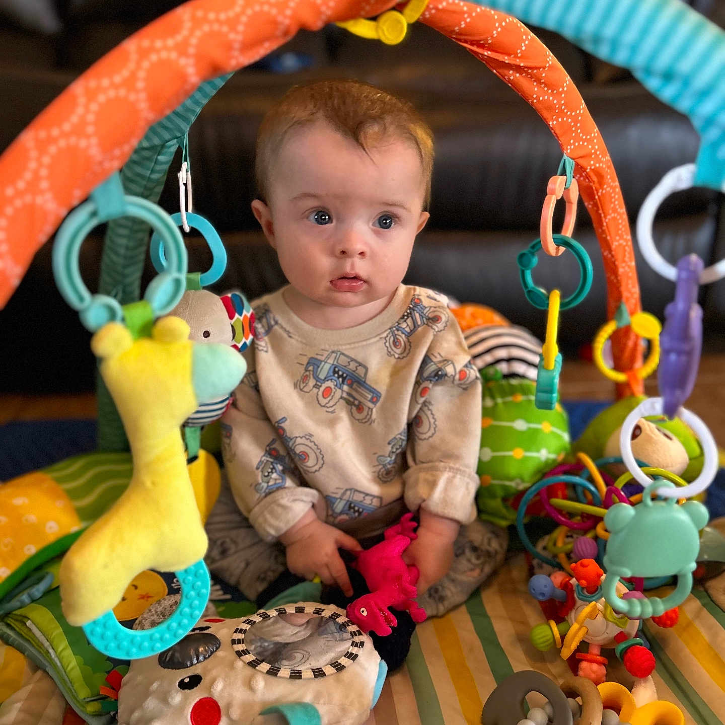 Lucas is registered to the contest to win money with this photo: accessories, baby, bodypart, couch, cream, cushion, face, finger, furniture, hand, head, homedecor, people, person, photography, playarea, plush, portrait, rattle, toy