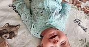 Frank is registered to the contest to win money with this photo: baby, infant, smiling, onesie, blanket, animal_print, bear, raccoon, fox, soft_toy, toys, child, cute, happy, lying_down, indoors, face, head, arm, fabric