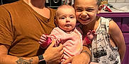 Nolan participe au concours pour gagner de l'argent avec cette photo : man, baby, child, family, kitchen, table, glass, bottle, microwave, coffee_machine, tattoo, watch, glasses, smile, pink_pajamas, short_hair, sleeveless_shirt, wooden_table, indoor, casual