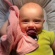 Lilou a rejoint le concours — aidez-le/la à gagner de superbes lots ! baby, pacifier, blanket, cushion, smiling, infant, face, child, toddler, comfort, soft, cute, lying_down, clothing, yellow_shirt, indoors, skin, head, expression, relaxation