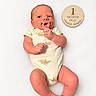 Kolsen is registered to the contest to win money with this photo: baby, infant, newborn, child, portrait, lying_down, pacifier, onesie, white_background, milestone, one_month_old, wooden_sign, smiling, face, hands, feet, indoors, close_up, family_photo, infant_photography