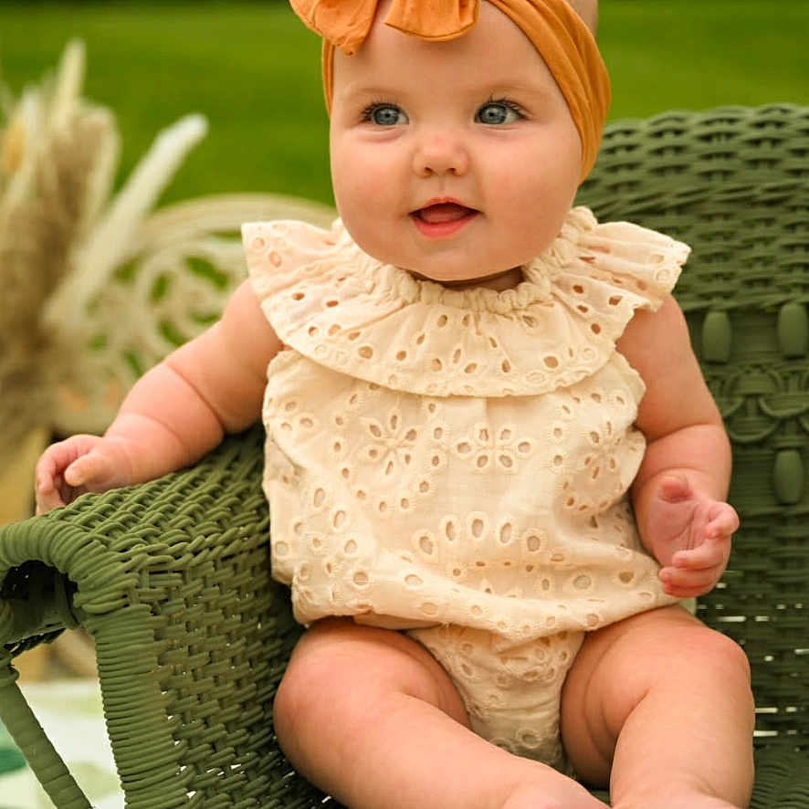 Elaine Marie is registered to the contest to win money with this photo: baby, infant, child, headband, smiling, wicker_chair, green, outdoor, garden, cute, portrait, sitting, clothing, happy, face, legs, feet, summer, natural_light, cute_baby