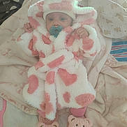 Kalayah joined the competition — help win amazing prizes! baby, infant, child, portrait, pacifier, pink, white, fuzzy_hat, animal_hat, blanket, bed, sleepwear, plush, slippers, bear_slippers, cozy, lying_down, indoor, soft_toys, smiling