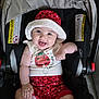 adorable, apparel, baby, car_seat, child, clothing, cute, face, happy, hat, indoors, infant, pacifier, person, polka_dot, red, seat, sitting, smile, white