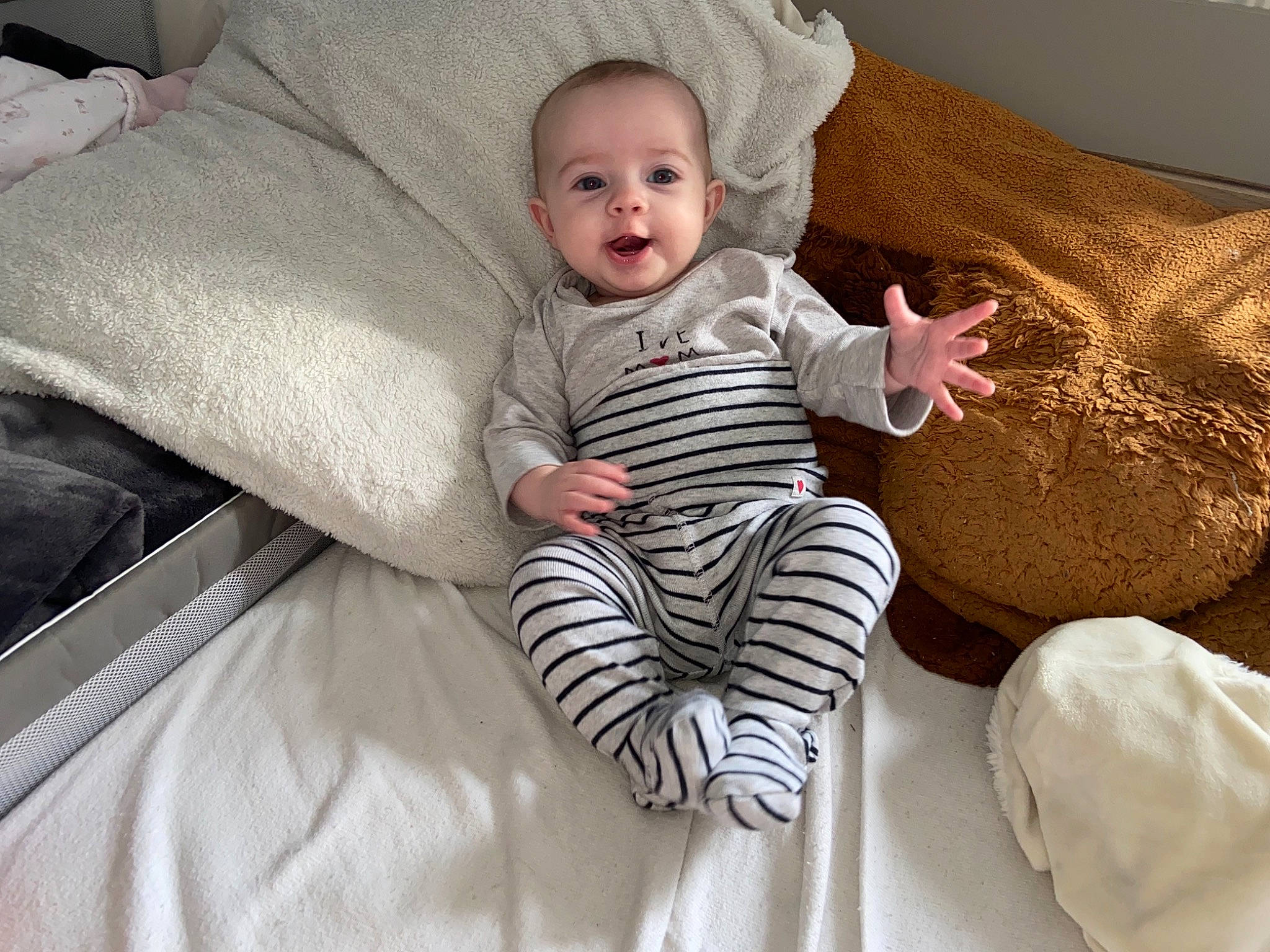 Lyana participe au concours pour gagner de l'argent avec cette photo : baby, baby_toddler_clothing, cheek, child, comfort, couch, eye, face, furniture, human_leg, leg, linens, person, pillow, skin, sleeve, smile, t_shirt, textile, throw_pillow