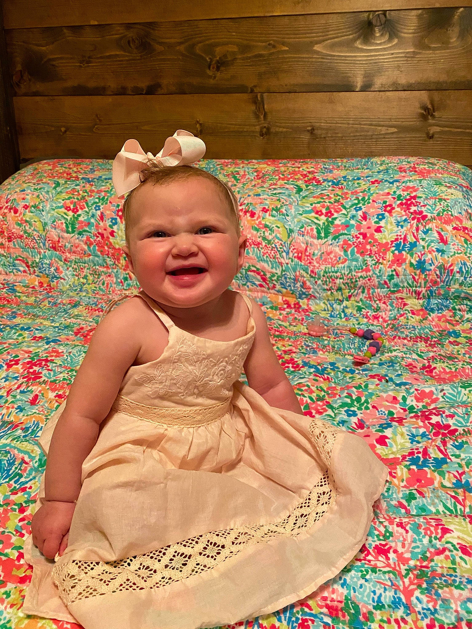 Stevie is registered to the contest to win money with this photo: baby, child, dress, pattern, person, pink, sitting, skin, smile, toddler