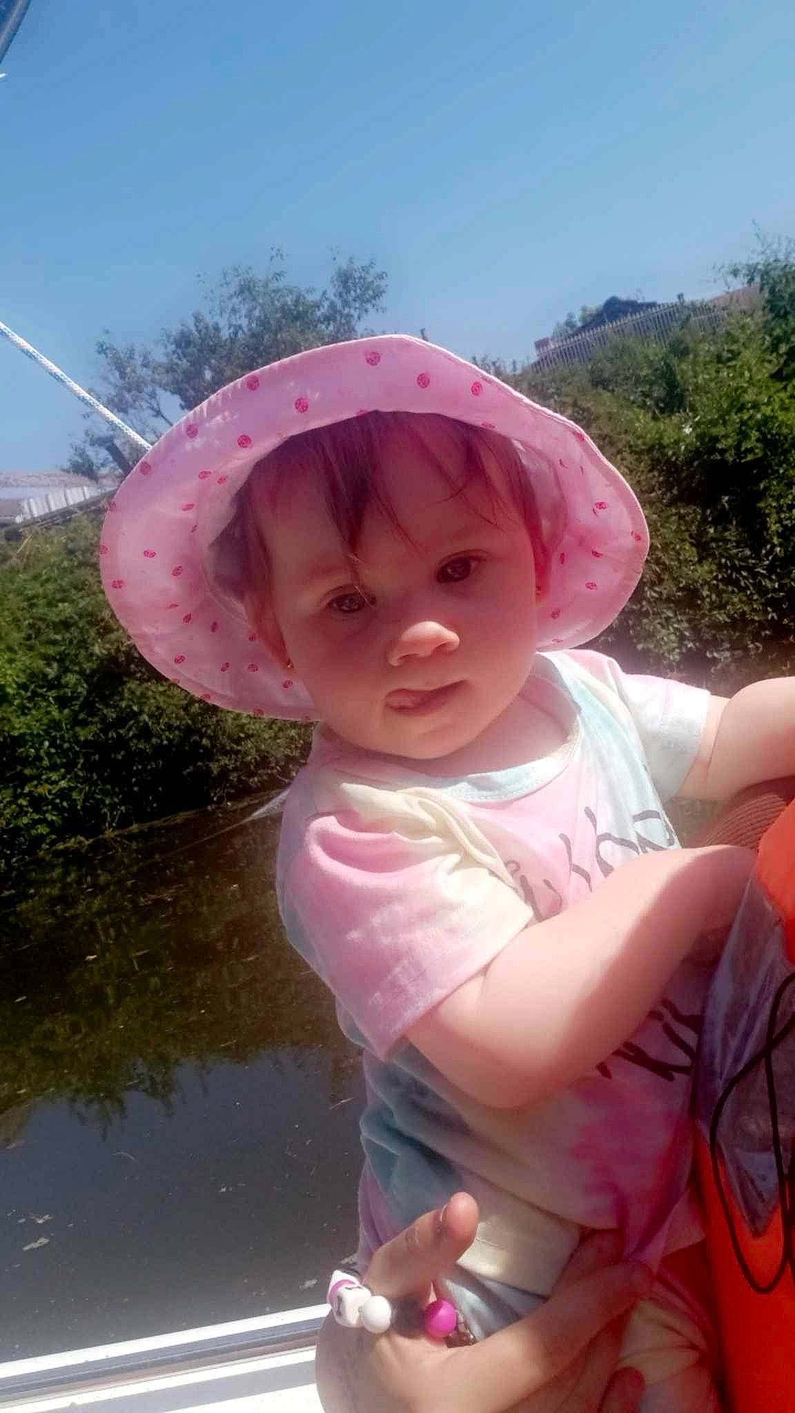 Inaya participe au concours pour gagner de l'argent avec cette photo : baby, baby_toddler_clothing, cap, child, fun, grass, happy, hat, headgear, leisure, magenta, person, personal_protective_equipment, pink, plant, recreation, sky, sun_hat, toddler, tree