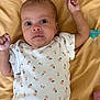 baby, infant, onesie, floral_pattern, blanket, lying_down, arms_up, cute, child, person, newborn, soft_fabric, pacifier, skin, expression, small_hands, indoors, portrait, young, sleepwear