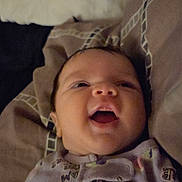 Ke'Nylah is registered to the contest to win money with this photo: baby, infant, smiling, onesie, bed, pillow, blanket, face, child, happy, indoors, sleepwear, cute, young, person, portrait, lying_down, cozy, soft, expression