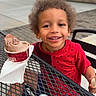 Ke'Aire joined the competition — help win amazing prizes! building, chair, child, cup, curly_hair, daytime, dessert, food, happy, ice_cream, metal_table, outdoor, person, plants, portrait, red_shirt, smiling, summer, table, urban