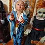 child, peace_sign, indoor, mirror, reflection, doll, halloween, costume, toy, teddy_bear, floor, wooden_floor, jacket, jeans, sneakers, blond_hair, playful, pose, face, person
