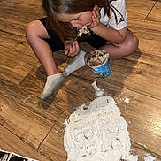 Josiah is registered to the contest to win money with this photo: child, ice_cream, floor, wooden_floor, white_powder, ultrasound_images, sitting, eating, spilled, mess, socks, shorts, tshirt, hair, indoor, person, flooring, container, spoon, curiosity