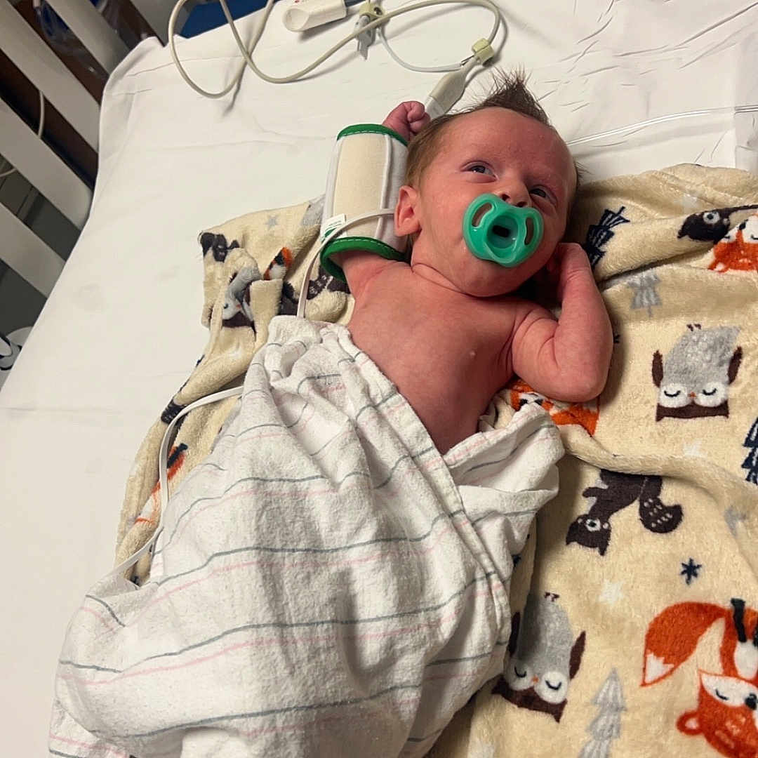 Asher is registered to the contest to win money with this photo: animal, architecture, baby, bed, bird, blanket, building, crib, cushion, face, furniture, head, homedecor, hospital, infantbed, newborn, penguin, person, photography, portrait