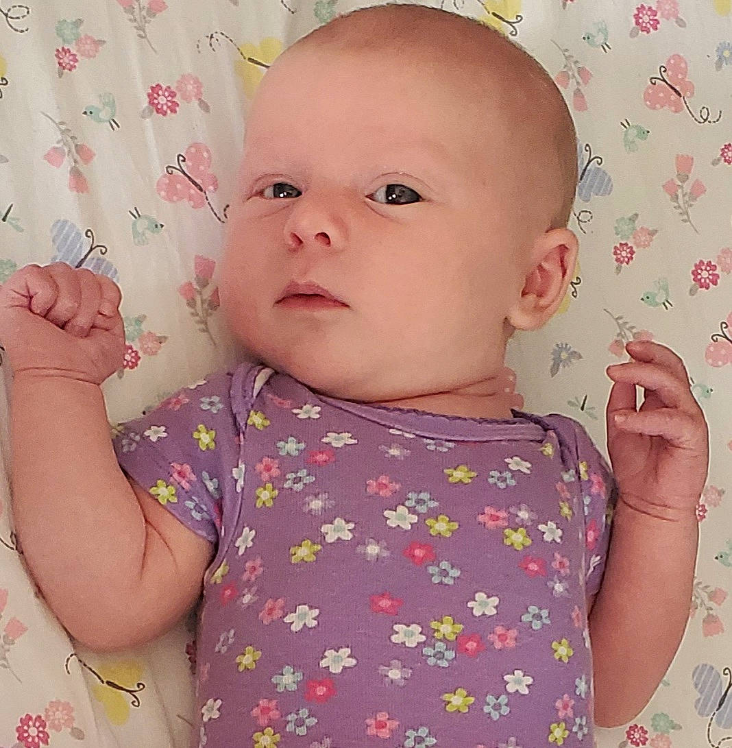 Ida is registered to the contest to win money with this photo: baby, baby_toddler_clothing, cheek, child, day_dress, ear, eyelash, linens, lip, nightwear, pattern, peach, person, pink, skin, toddler, wallpaper