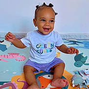 Hélio a rejoint le concours — aidez-le/la à gagner de superbes lots ! baby, bright, child, colorful, cute, floor, fun, hair, happy, indoor, infant, person, play_mat, playtime, puffs, shorts, sitting, smiling, toy, tshirt