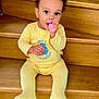 toddler, child, yellow_clothing, stairs, wooden_stairs, indoors, baby, cute, sitting, thumb_sucking, curly_hair, portrait, young_child, one_person, infant, face, expression, comfort, home, casual