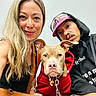 Martin Otis Jenkins is registered to the contest to win money with this photo: dog, puppy, pit_bull, pet, portrait, selfie, people, woman, man, faces, smiling, red_jacket, collar, leash, indoor, close_up, fashion, handbag, sunglasses, companion_animal