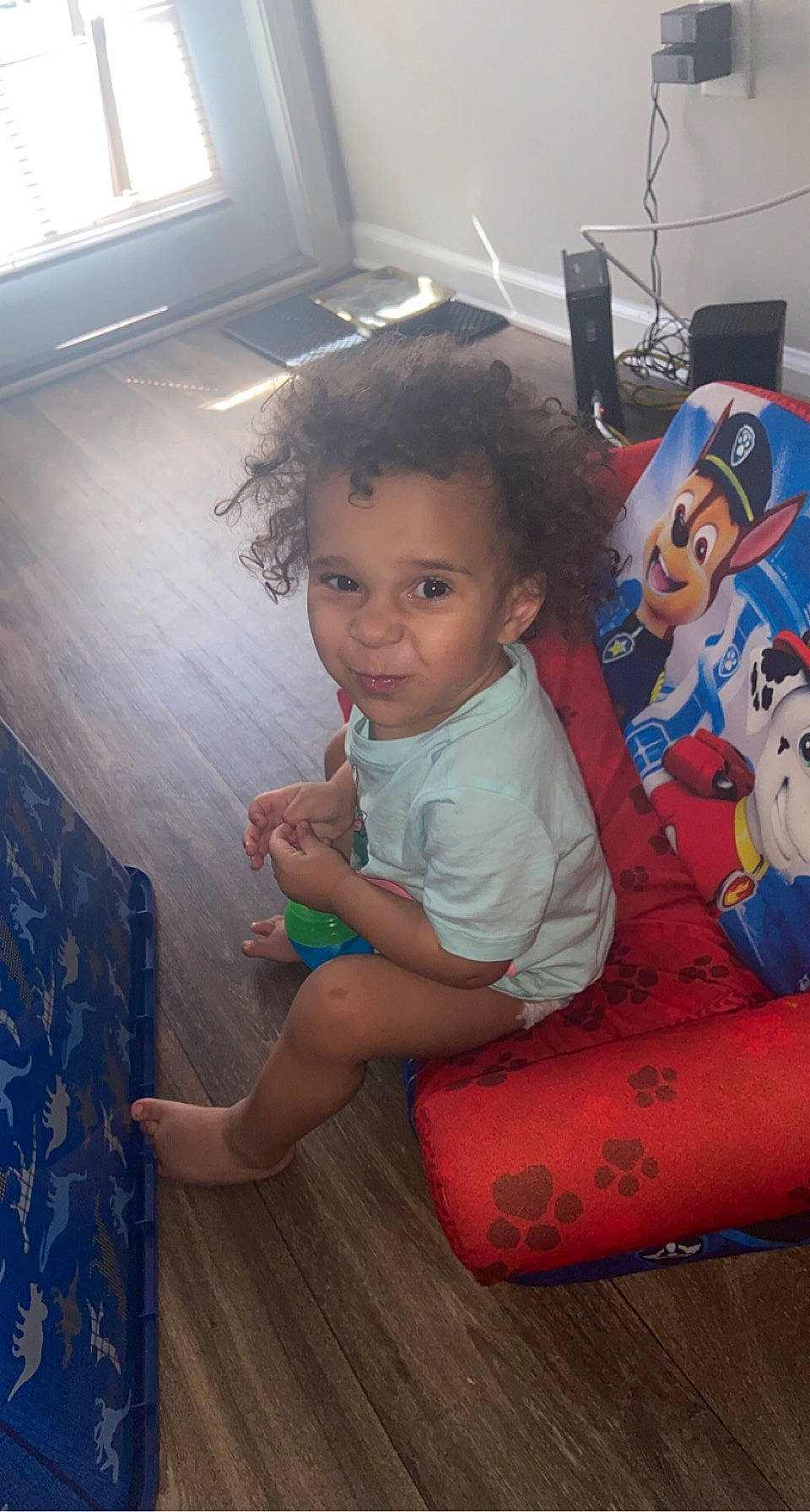 Zaidyn is registered to the contest to win money with this photo: chair, child, dress, finger, floor, flooring, foot, fun, happy, human_leg, leisure, mammal, person, sitting, skin, standing, t_shirt, thigh, toddler, trunk