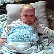 Jase Jr is registered to the contest to win money with this photo: baby, blanket, pillow, bed, bedding, child, cozy, sleepwear, infant, cute, comfort, indoors, person, soft, resting, young_child, warm, fabric, sleep, relaxation