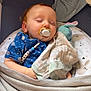 baby, sleeping, pacifier, blanket, plush_toy, blue_shirt, crib, cozy, infant, child, soft_fabric, nursery, peaceful, cuddling, toddler, comfort, resting, indoor, cute, sleep