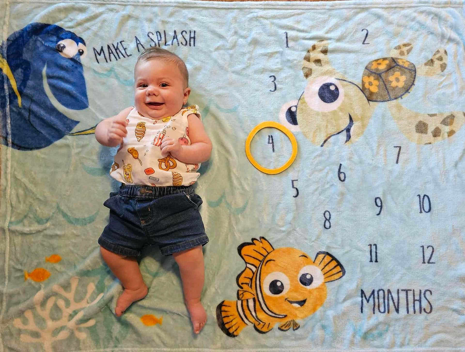 Ruben joined the competition — help win amazing prizes! baby, infant, milestone_blanket, cartoon_fish, cartoon_turtle, yellow_ring, smiling, lying_down, clothing, shorts, sleeveless_shirt, baby_milestone, baby_photography, cute, child, indoor, colorful, playful, happy, portrait