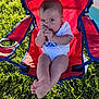Ruben is registered to the contest to win money with this photo: baby, child, outdoor, grass, red_chair, camping_chair, sitting, cute, infant, hand, face, feet, sunlight, summer, white_onesie, expression, portrait, nature, relaxing, playful