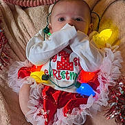 Nala joined the competition — help win amazing prizes! baby, blanket, celebration, christmas, clothing, cute, decorations, face, festive, holiday, indoors, infant, lights, person, red, seasonal, smiling, tinsel, tutu, white