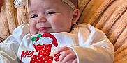 Nala is registered to the contest to win money with this photo: baby, blanket, bow, cheerful, child, christmas, clothing, cute, decorations, festive, gift, headband, holiday, holiday_outfit, indoors, infant, portrait, red, smiling, white