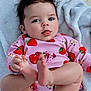 baby, bare_feet, child, closeup, curly_hair, cute, diaper, expression, happy, indoor, infant, person, pink_clothing, playful, portrait, relaxed, skin, soft_texture, strawberry_pattern, towel