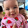 baby, child, person, smile, face, pink_clothing, strawberry_pattern, wet_hair, hand, manicure, outdoor, tent, sky, happy, cute, portrait, closeup, holding, people, background