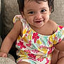 toddler, child, smiling, sitting, colorful_clothing, floral_pattern, couch, indoors, cute, happy, portrait, young_child, baby, short_hair, bright, comfortable, playful, skin, one_person, casual