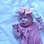 baby, infant, pink_bow, headband, pink_outfit, blanket, lying_down, cute, expression, fists, newborn, child, soft_texture, indoors, portrait, adorable, small_hands, clothing, headwear, resting