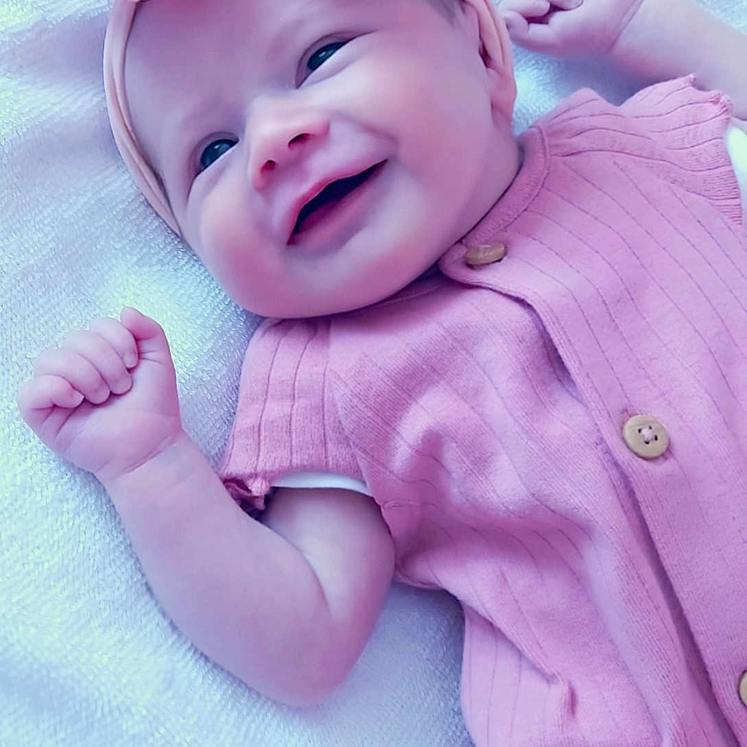 Rayne joined the competition — help win amazing prizes! adorable, baby, baby_girl, blanket, cheerful, child, closeup, clothing, cute, fist, happy, headband, infant, lying_down, newborn, pink_bow, pink_outfit, portrait, smiling, soft_texture