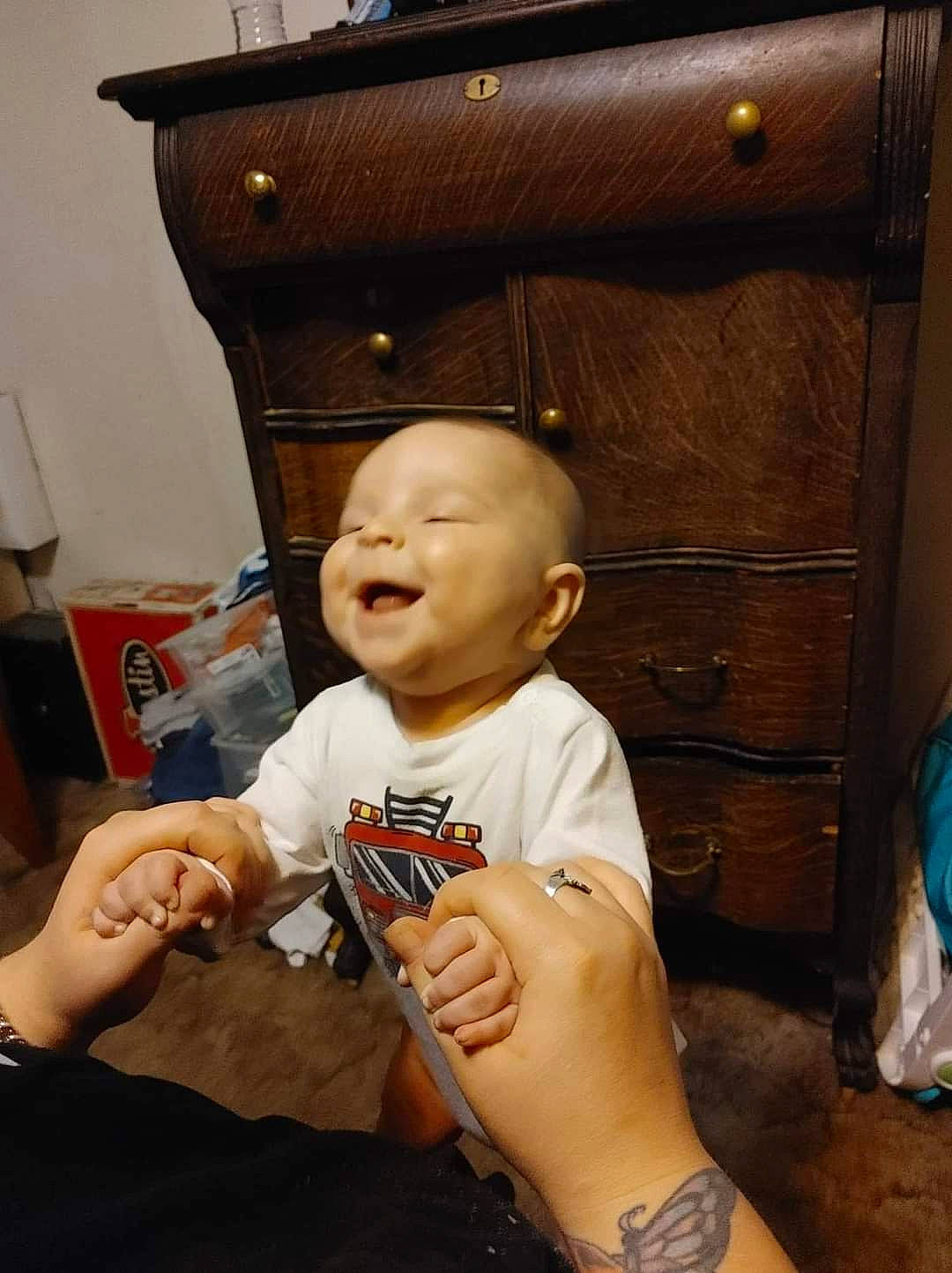 Jaxon is registered to the contest to win money with this photo: baby, box, cabinetry, chest_of_drawers, child, cupboard, drawer, elbow, fun, gesture, hand, happy, person, room, shelf, sitting, smile, thumb, toddler, wood