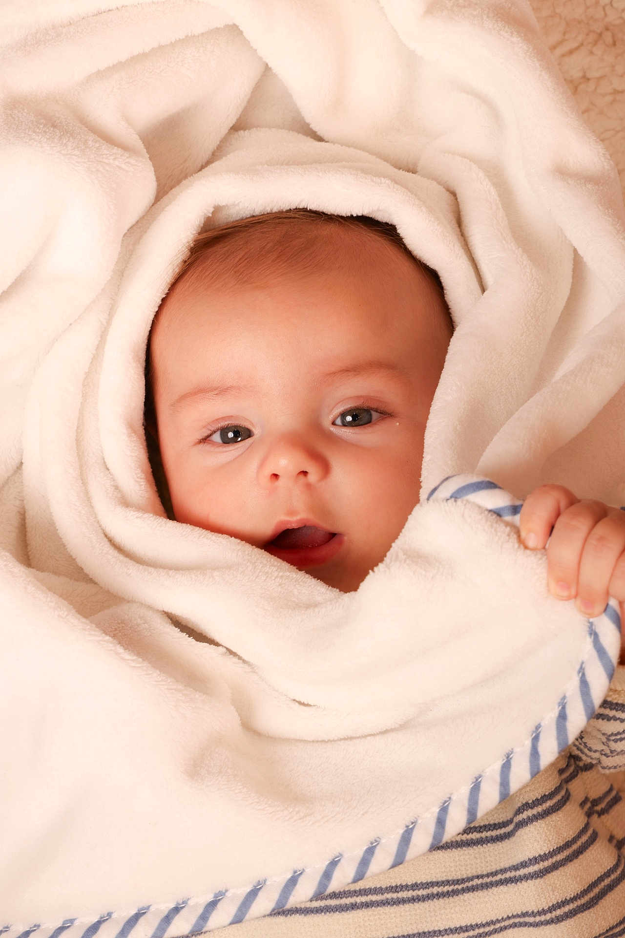 Basile participe au concours pour gagner de l'argent avec cette photo : baby, blanket, soft, wrapped, face, infant, hand, blue_stripes, cute, cozy, warm, skin, eyes, portrait, newborn, child, toddler, comfort, closeup, expression