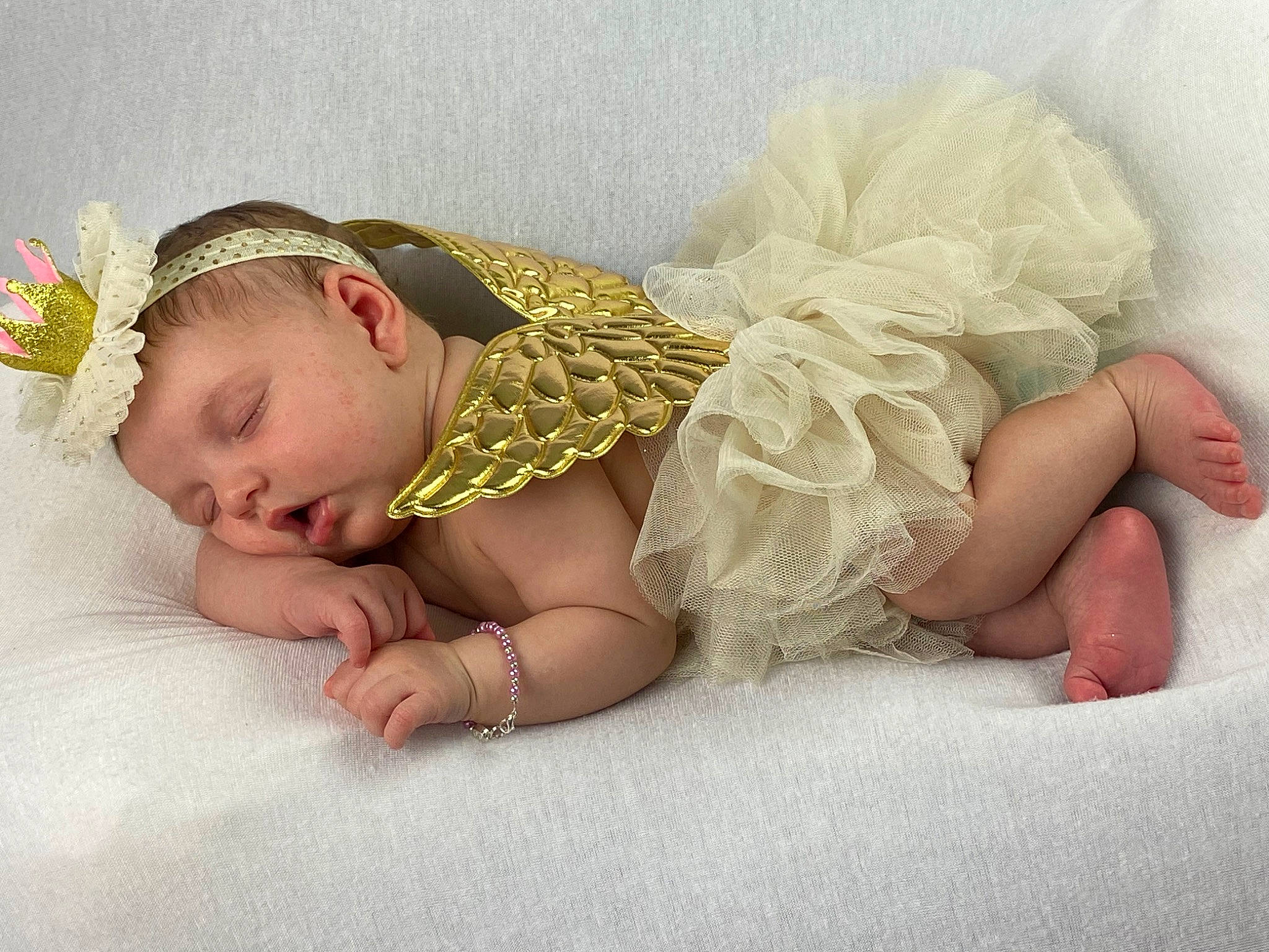 Emersyn is registered to the contest to win money with this photo: arm, baby, baby_sleeping, baby_toddler_clothing, bedding, comfort, finger, flooring, foot, hair_accessory, headband, headgear, headpiece, human_body, human_leg, leg, linens, person, skin, textile