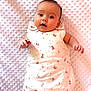 adorable, baby, blanket, child, curious, cute, expression, face, floral_pattern, head, indoors, infant, lying_down, newborn, portrait, skin, sleeping_sack, small_hands, soft_texture, young_child
