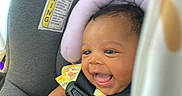 Amaiah is registered to the contest to win money with this photo: baby, car_seat, child, smiling, happiness, seatbelt, yellow_clothing, floral_pattern, headrest, infant, safety, happy, indoors, person, cute, small_child, seat, car, colorful, curtain