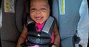 Amaiah is registered to the contest to win money with this photo: baby, baby_girl, car_seat, cheerful, child, child_seat, cute, face, happy, indoors, infant, person, pink_clothing, portrait, safety, seatbelt, secure, smiling, straps, young_child
