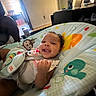 baby, smiling, infant, baby_seat, colorful, animal_print, indoor, furniture, person, happy, child, seat_belt, cute, home, toy_pattern, playful, young_child, cozy, portrait, relaxed