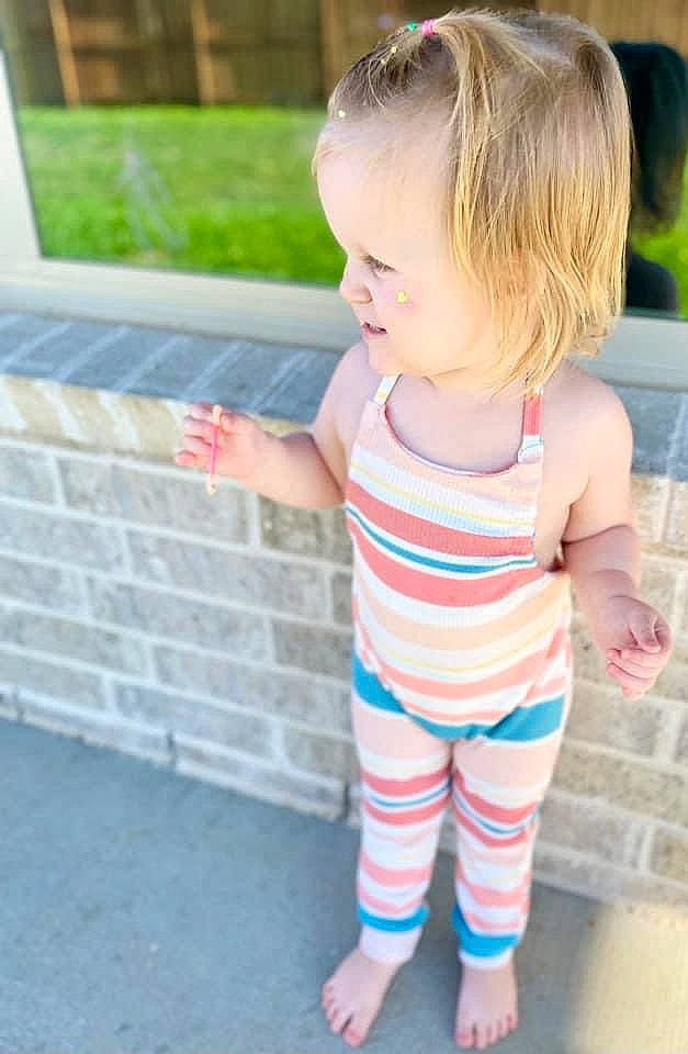 Sophie is registered to the contest to win money with this photo: baby, baby_toddler_clothing, child, dress, electric_blue, grass, hair, happy, head, human_body, human_leg, leg, pattern, person, pink, skin, sleeve, smile, t_shirt, thigh